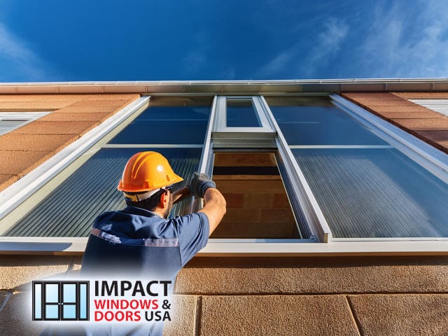 male professional handyman technician working performing installation of impact windows to commercial building